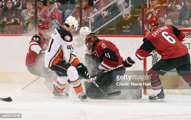 Goalie Mike Smith of the Arizona Coyotes covers the puck after making a save as Corey Tropp of the Anaheim Ducks skates in and Kevin Connauton and...