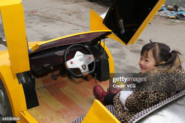 Girl drives miniature Lamborghini made by Chinese farmer Guo Liangyuan on the street on February 21, 2017 in Zhengzhou, Henan Province of China....