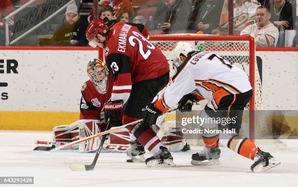 Andrew Cogliano of the Anaheim Ducks and Oliver Ekman-Larsson of the Arizona Coyotes battle for a loose puck in front of goalie Marek Langhamer of...