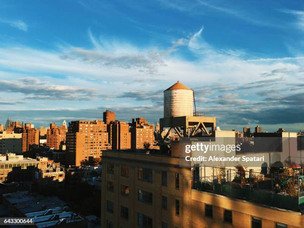 water tower on the roof of a building in chelsea district, new york - rooftop new york photos et images de collection