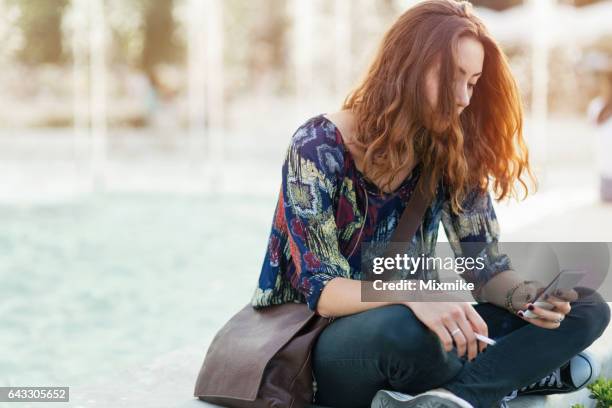 在一個城市噴泉上抽煙的金髮女孩 - smoking girl 個照片及圖片檔
