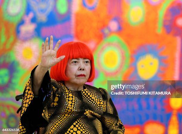 Japanese artist Yayoi Kusama waves at a photo session during a press preview of her exhibition titled "My Eternal Soul" at the National Art Center in...