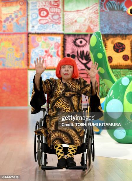 Japanese artist Yayoi Kusama waves at a photo session during a press preview of her exhibition titled "My Eternal Soul" at the National Art Center in...