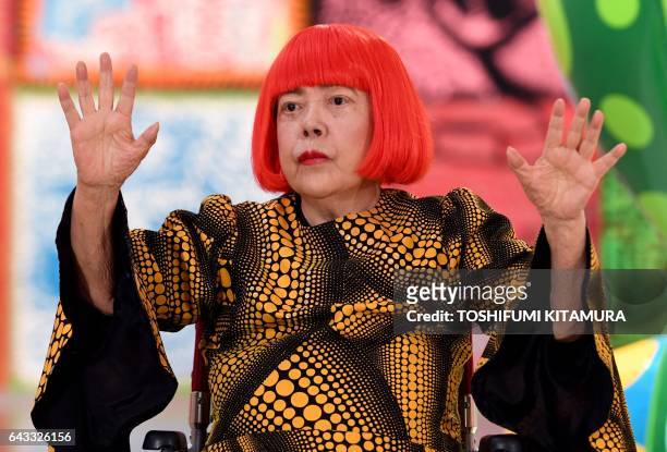 Japanese artist Yayoi Kusama waves at a photo session during a press preview of her exhibition titled "My Eternal Soul" at the National Art Center in...