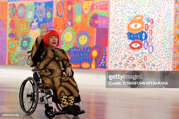 Japanese artist Yayoi Kusama waves at a photo session during a press preview of her exhibition titled "My Eternal Soul" at the National Art Center in...