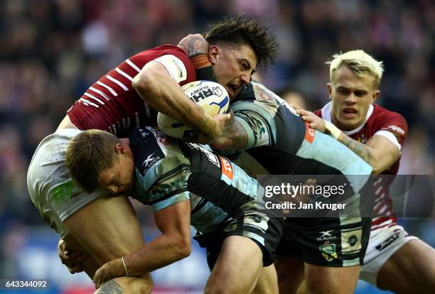 Anthony Gelling of Wigan Warriors is tackled by Jayden Brailey and Andrew Fifita of Cronulla-Sutherland Sharks during the Dacia World Club Challenge...