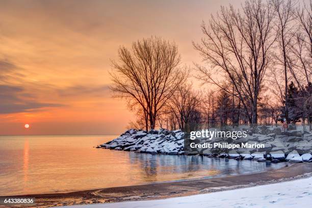 sunrise over lake and snowy trees and rocks - lake ontario stock pictures, royalty-free photos & images