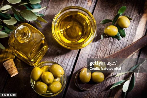 olive oil and green olives shot from above - olive stock pictures, royalty-free photos & images
