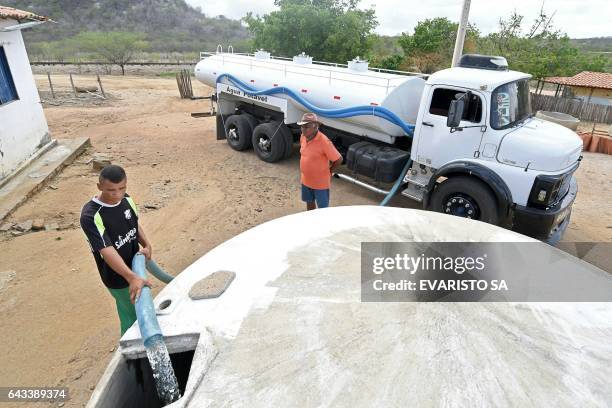 Man fills a community cistern with water from a water truck in the rural area of Quixeramobim, in Ceara State, on February 8 during the worst drought...