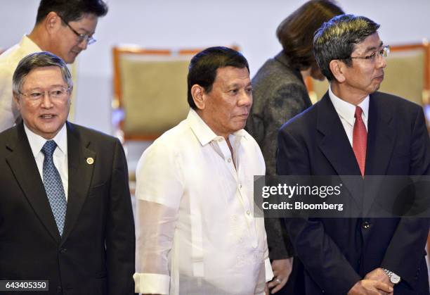 Rodrigo Duterte, the Philippines' president, center, Carlos Dominguez, the Philippines' secretary of finance, left, and Takehiko Nakao, president of...