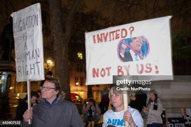 Protesters hold up placards during a rally in Parliament Square against US president Donald Trump's state visit to the UK on February 20, 2017 in...