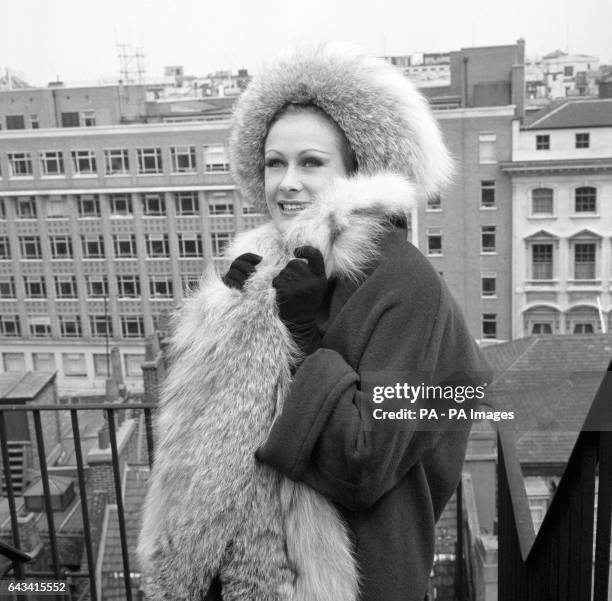 Aldine Honey from South Africa models a three-quarter length angora coat trimmed with lynx fur and matching hat during rehearsals in London for the...