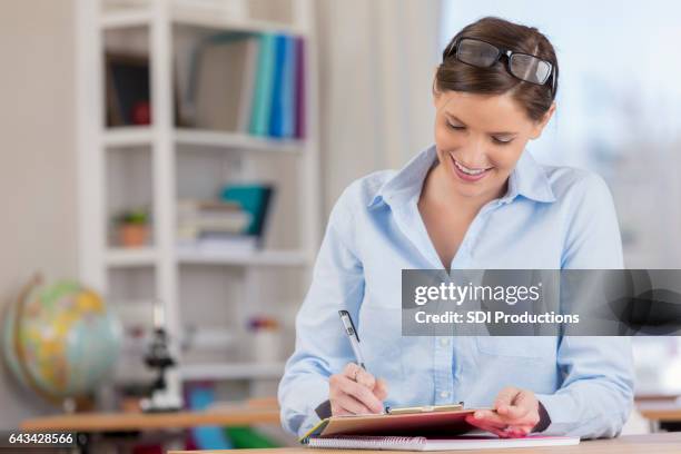 focused elementary school teacher grades papers before class - grading stock pictures, royalty-free photos & images