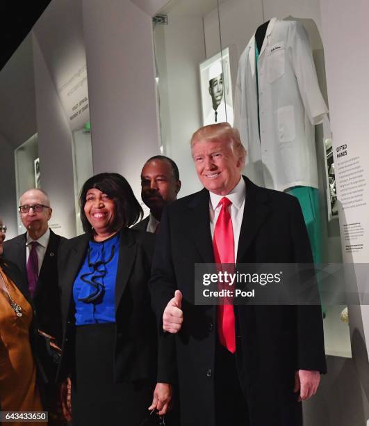 President Donald Trump, Ivanka Trump and Housing and Urban Development nominee Ben Carson pose in front of the Ben Carson exhibit during a visit to...
