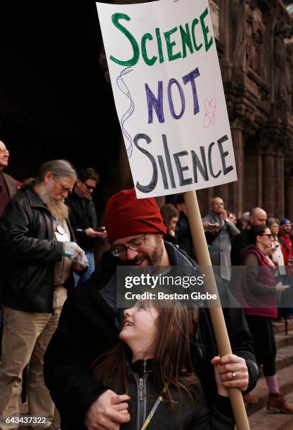 Chris Racine of Worcester, top, stands with his daughter Sophie as scientists, science advocates and community members gather in Copley Square in...