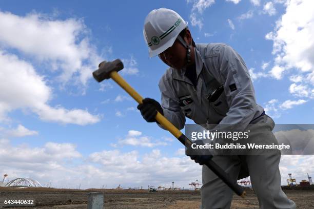 Construction worker swings a sledgehammer at the site of Japan's first large scale casino resort at Yumeshima Island on February 21 in Osaka, Japan....
