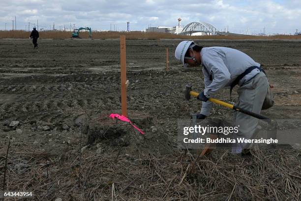 Construction worker swings a sledgehammer at the site as Japan's first large scale casino resort at Yumeshima Island on February 21 in Osaka, Japan....