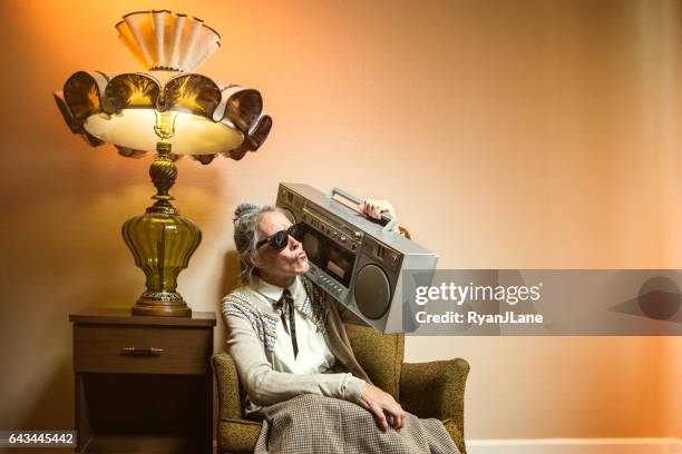 oma met behulp van meerdere moderne elektronica - rocking chair stockfoto's en -beelden