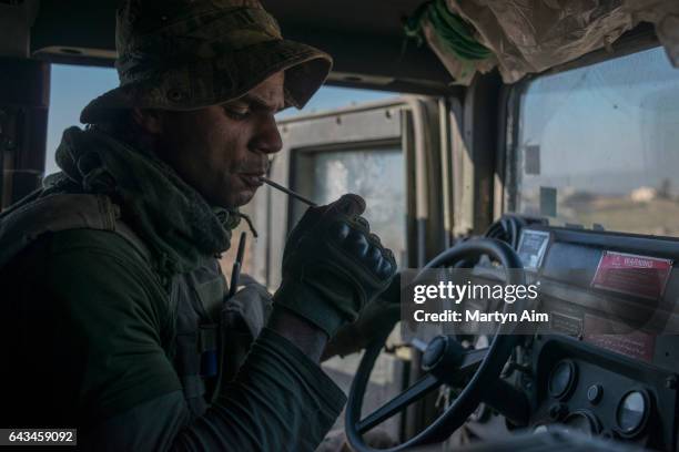 An Iraqi Emergency Response Division soldier soldier lights a cigarette in his Humvee before entering the Islamic State occupied village of Abu Saif,...