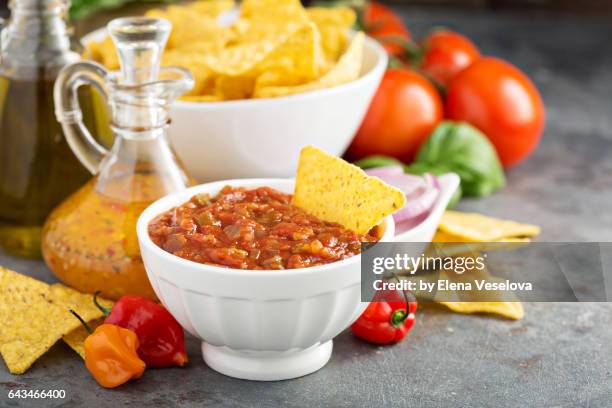 red tomato spicy salsa with chips - salsa stock-fotos und bilder