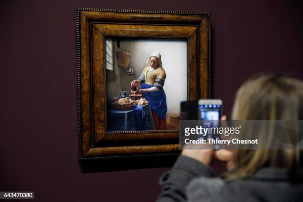 Visitor takes a picture of the painting "The Milkmaid" by Dutch painter Johannes Vermeer during a press visit of the exhibition "Vermeer and the...