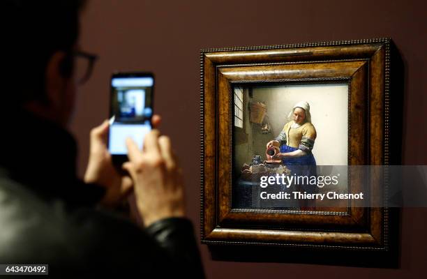 Visitor takes a picture of the painting "The Milkmaid" by Dutch painter Johannes Vermeer during a press visit of the exhibition "Vermeer and the...