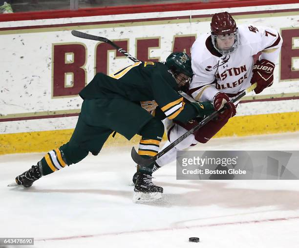 Boston College's Connor Moore is tripped up by University of Vermont's Travis Blanleil during the first period. Boston College hosts University of...