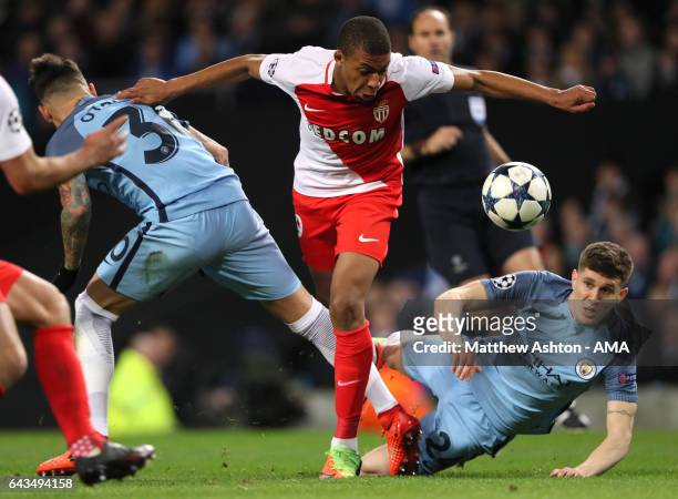 Kylian Mbappe-Lottin of Monaco competes with John Stones of Manchester City during the UEFA Champions League Round of 16 first leg match between...