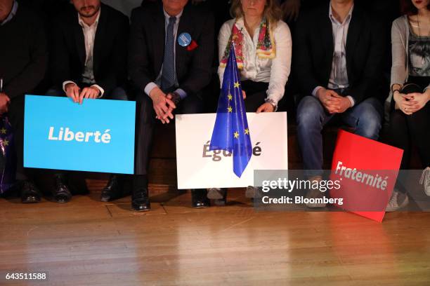 Attendees hold campaign placards stating 'Liberte, Egalite, Fraternite' as Emmanuel Macron, French presidential candidate, not pictured, speaks at a...