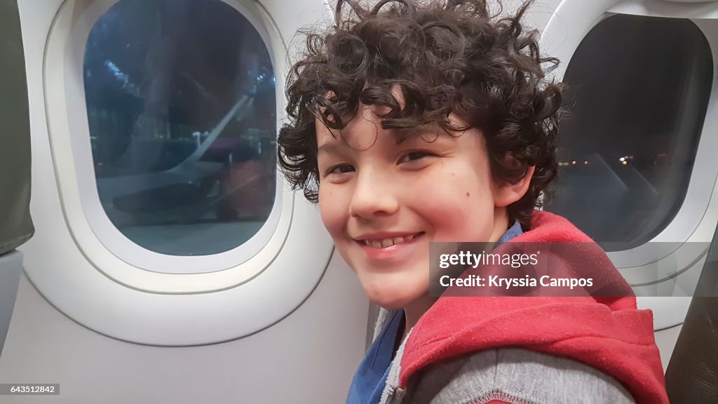 Young boy smiles in an airplane