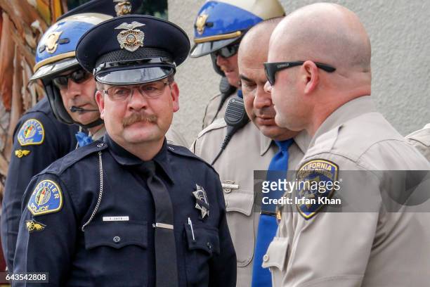 Whittier police officer Richard Jensen is surrounded by CHP officers who escorted the hearse carrying slain Whittier police officer Keith Boyer...