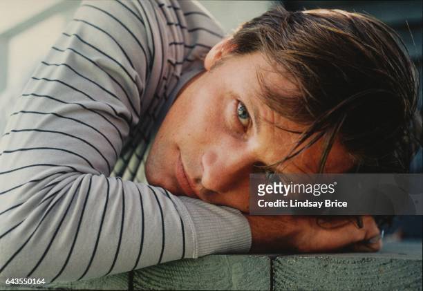 Actor Viggo Mortensen poses for portrait, rests head on hand on landing of a blue painted porch outdoors on April 13, 1997 in Beverly Hills,...