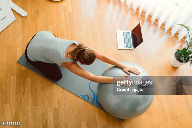 young pregnant woman exercises at home - exercise computer stock pictures, royalty-free photos & images