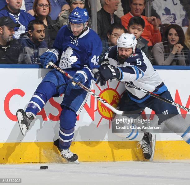 Mark Stuart of the Winnipeg Jets battles against Nazem Kadri of the Toronto Maple Leafs during an NHL game at Air Canada Centre on February 21, 2017...