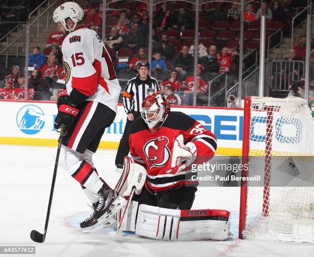 Zack Smith of the Ottawa Senators screens goalie Cory Schneider of the New Jersey Devils as a shot by Erik Karlsson of the Senators goes into the net...