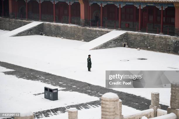 Two Chinese paramilitary guards walk in the snow at the Forbidden City in Beijing on February 22, 2017.