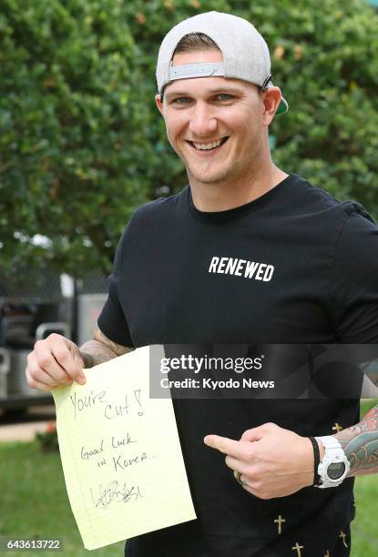 Miami Marlins non-roster spring training invitee Brandon Barnes shows a sign put on his locker by teammates after an outfield collision with Ichiro...