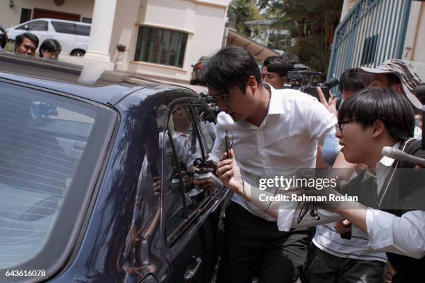 South Korean journalists scramble to get information from an unidentified man as he exits the North Korean Embassy compound on February 22, 2017 in...