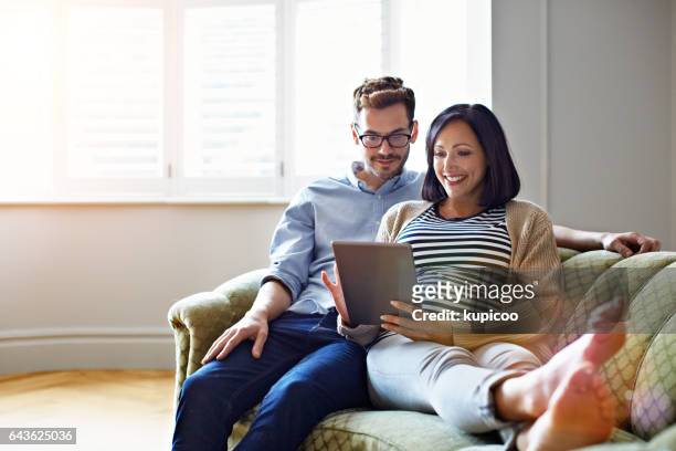 finden sie das perfekte babykleidung online - couple tablet house stock-fotos und bilder
