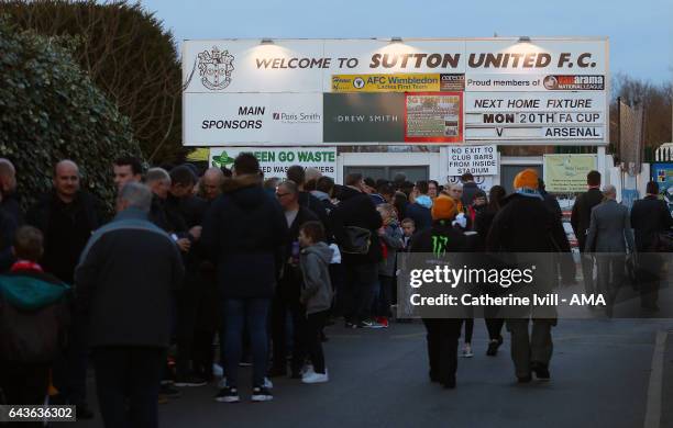 Fans wait to go in under the Sutton United fixture board The Borough Sports Ground, Gander Green stadium before The Emirates FA Cup Fifth Round match...