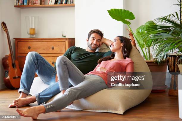 taking it easy today - man talking to woman living room stock pictures, royalty-free photos & images