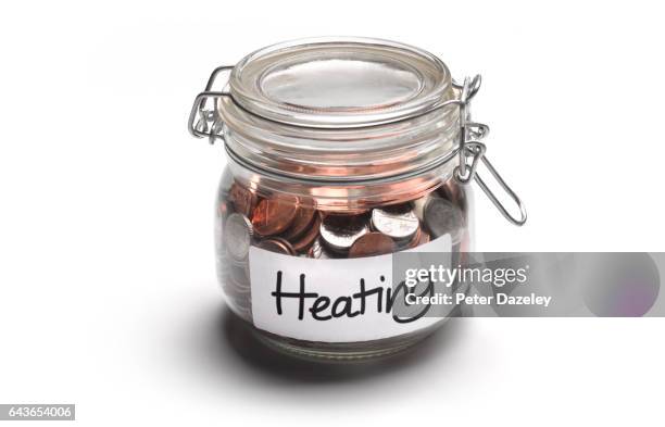heating jar of money coins - saving for a rainy day englische redewendung stock-fotos und bilder