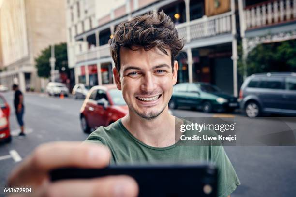 young man taking self portrait in the city - セルフィー　男性 ストックフォトと画像