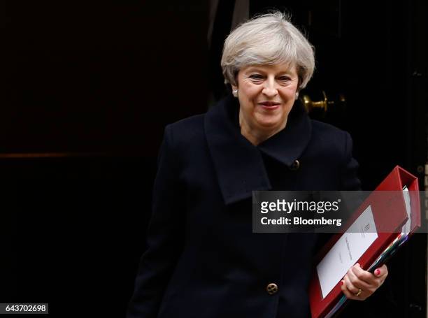 Theresa May, U.K. Prime minister, carries a document folder as she leaves 10 Downing Street to attend the weekly question-and-answer session in the...