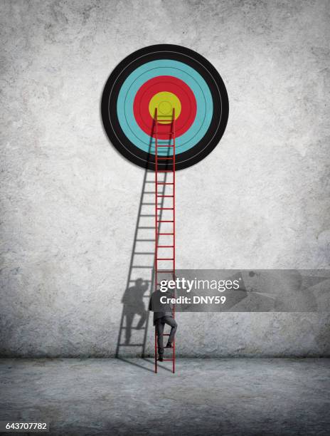 businessman climbing ladder to reach target - bull's eye stock pictures, royalty-free photos & images