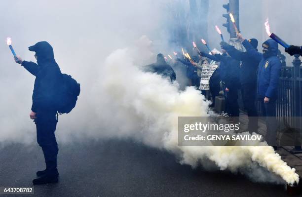 Supporters of various Ukrainian nationalist parties light smoke bombs as they chant slogans during a rally in front of Ukrainian Parliament, in...