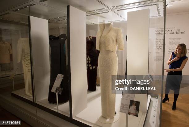 Television reporter gestures as she stands next a dress , known as the "Elvis Dress", by designer Catherine Walker, and worn by Britain's Diana,...