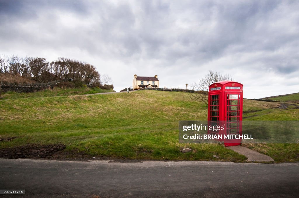 Red British style telephone box in a country setting