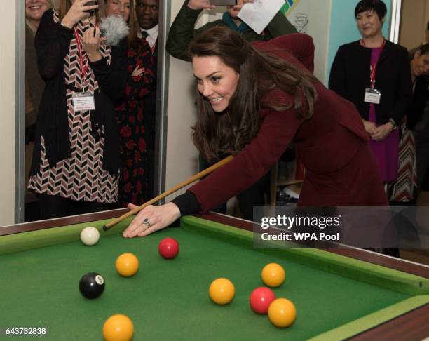 Catherine, Duchess of Cambridge plays pool during her visit to MIST, a child and adolescent mental health project, part of Action for Children which...