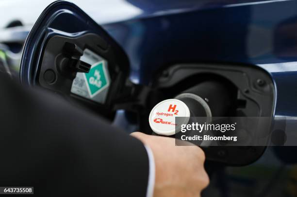 Driver places a hydrogen fuel pump into a Mirai hydrogen fuel powered automobile, manufactured by Toyota Motor Corp., at Royal Dutch Shell Plc's...